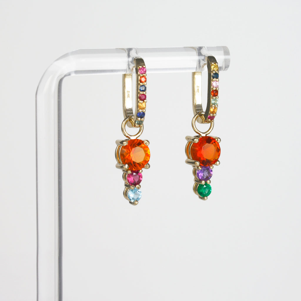 Each hoop is adorned with a unique arrangement of multicolor sapphires in vivid hues, which have been carefully handpicked to create mesmerizing combinations. 