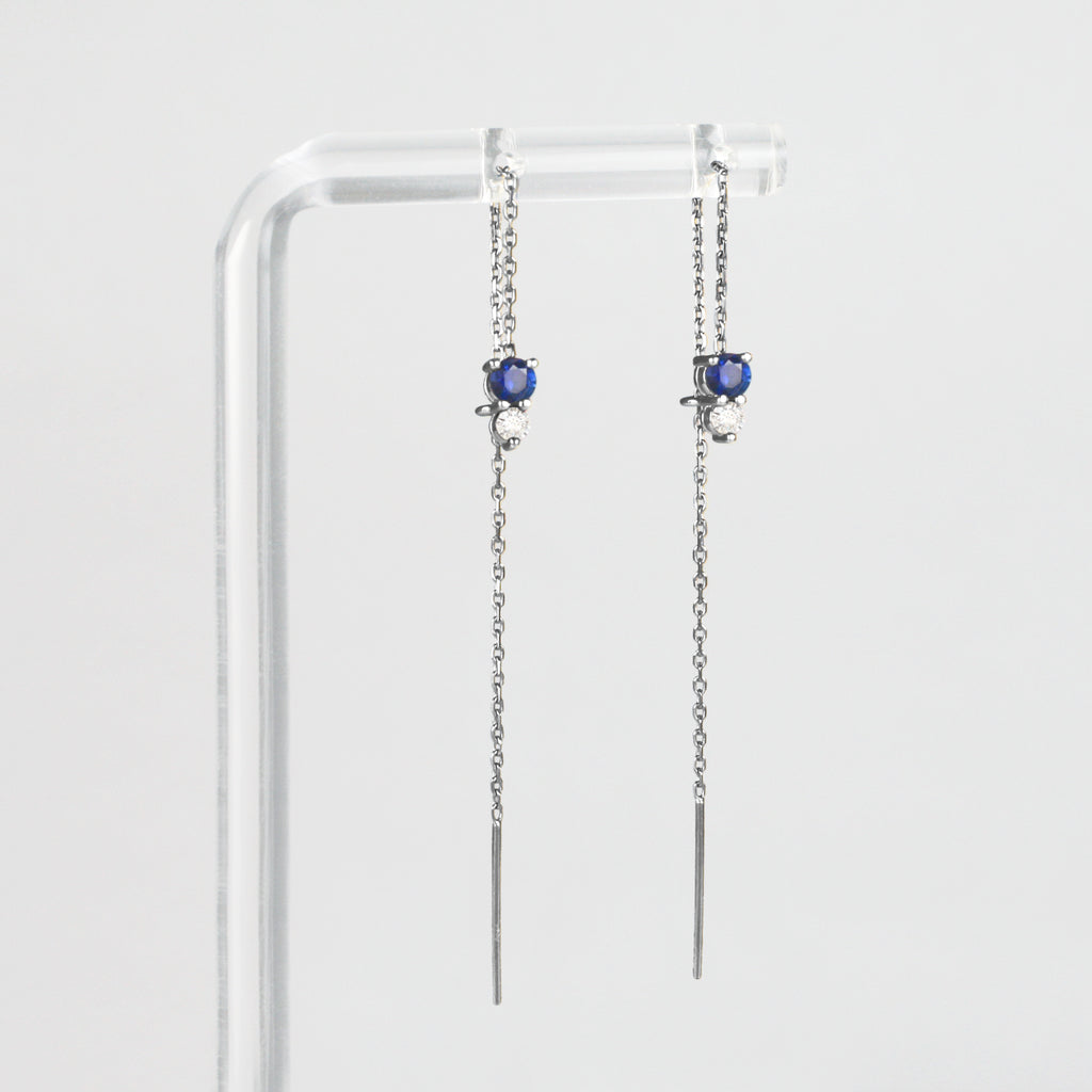 An intense sapphire and a sparkly diamond, beautifully matched, dangle at the end of a delicate gold chain. Decide the height of your gemstones by threading the chain through your ear and passing it through the jump ring attached at the back of the precious gems.