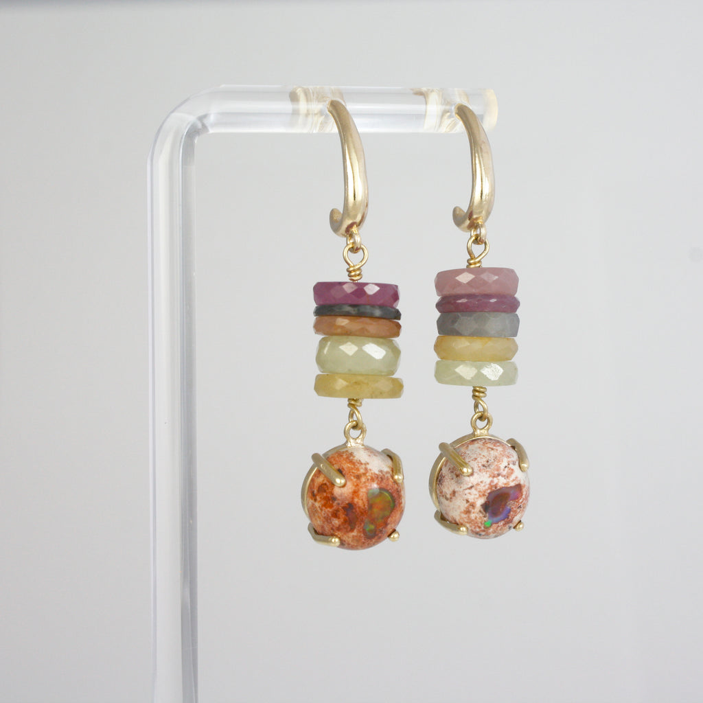 This unique pair of hanging earrings features rare Umbra sapphires from Tanzania, showcasing an exquisite range of shifting colors, perfectly paired with vibrant Mexican boulder opals. The combination is bold and earthy—an elegant celebration of natural beauty.
