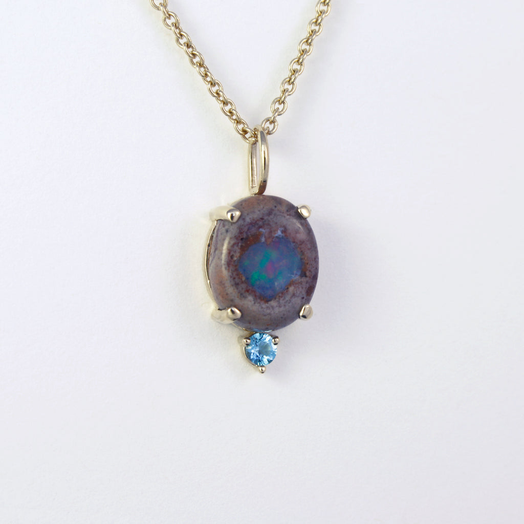 This simple charm features a unique Mexican blue boulder crystal opal and a sky blue topaz. Raw and sophisticated, the perfect statement. 