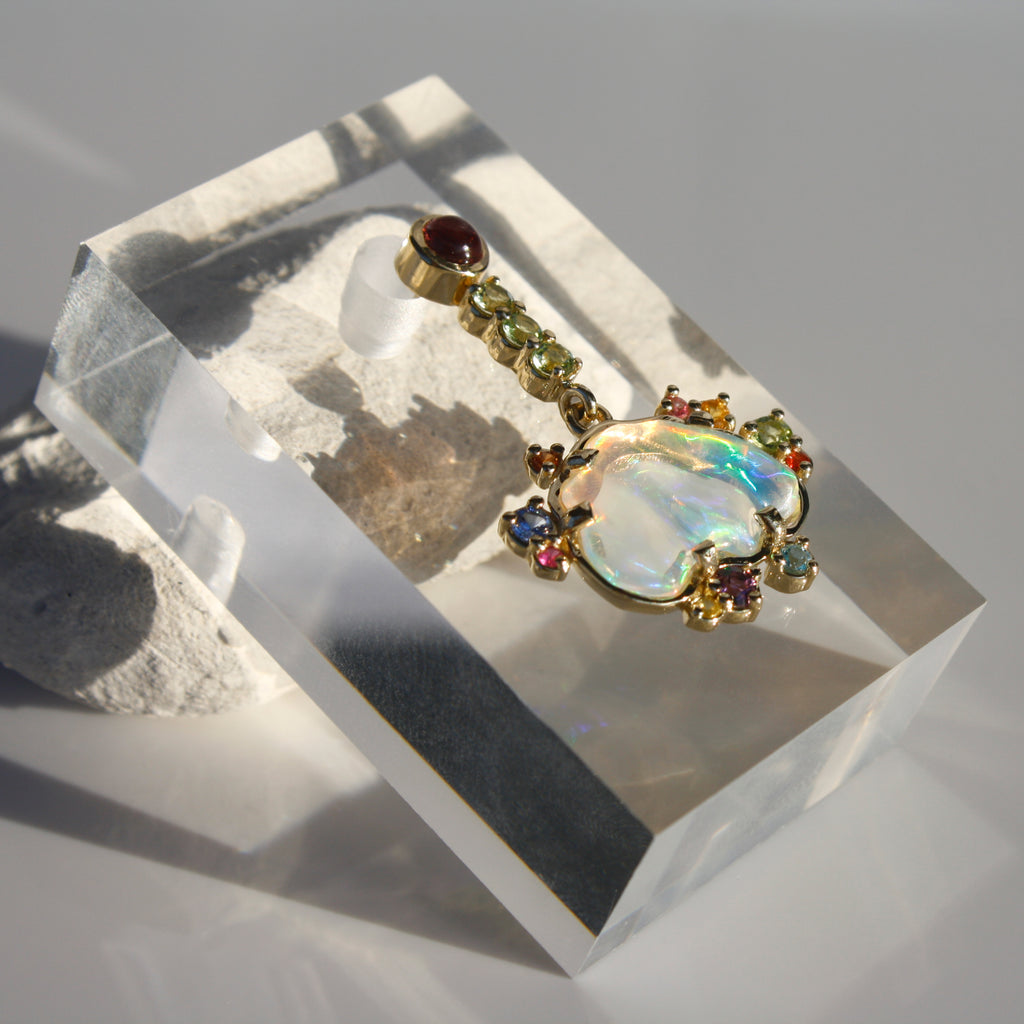 Dreamy and fascinating Mexican crystal opals with rainbow fire and flashes of color accompanied by tourmalines, sapphires, topaz, amethysts and peridots set in 14k gold.