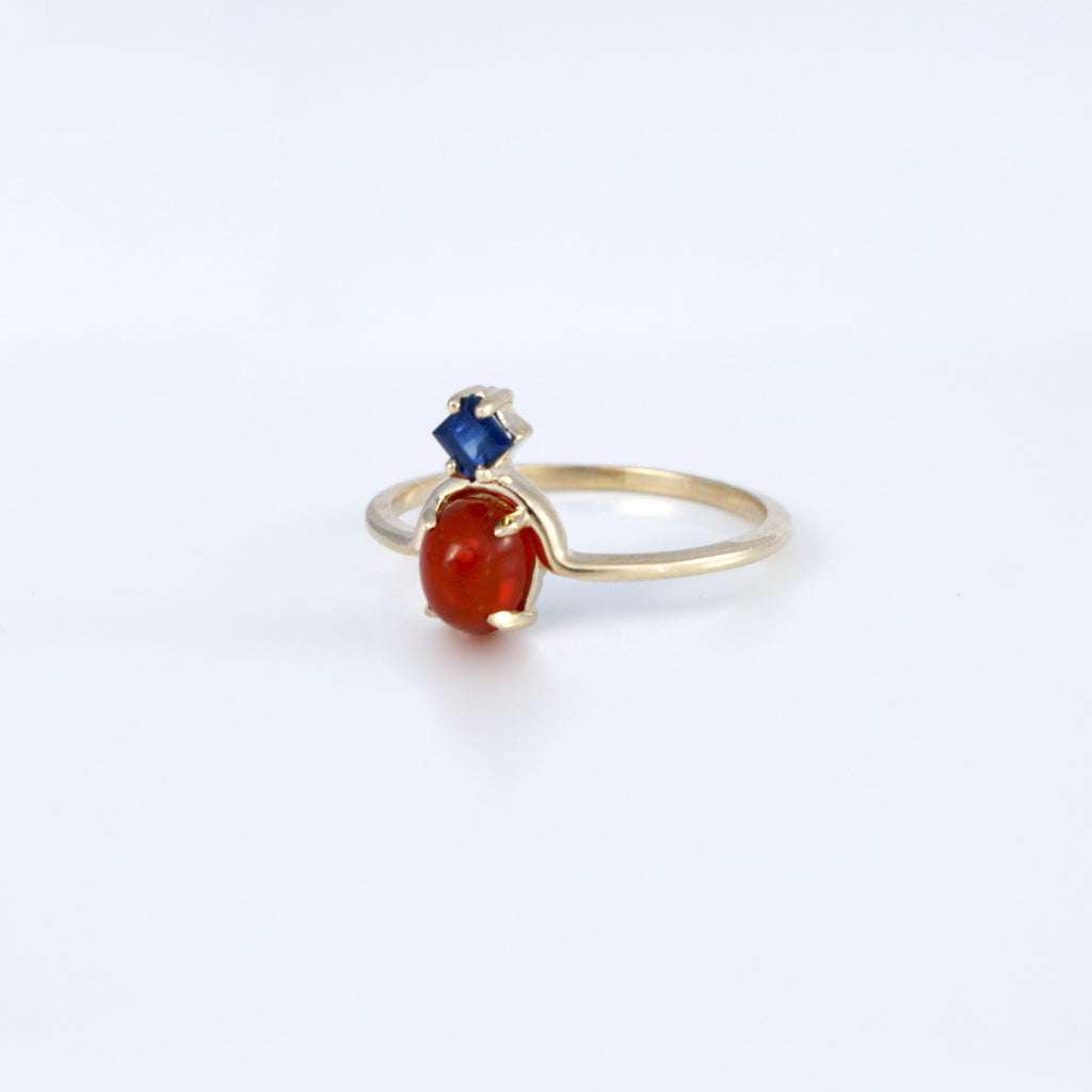 Delicate 14k gold ring featuring Mexican fire opal paired with a princess cut deep blue sapphire creating an unexpected and exciting combination. 