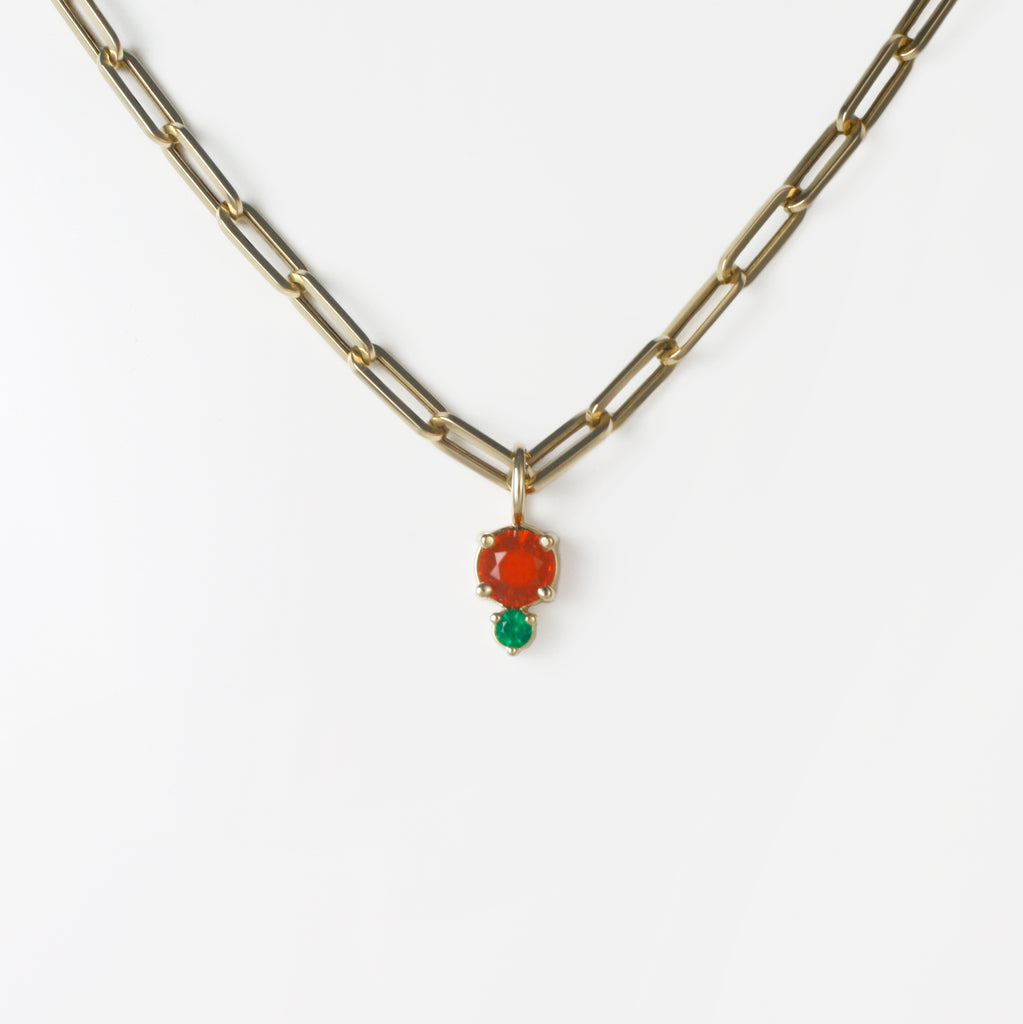Vibrant red-orange Mexican fire opal alongside a lively emerald.