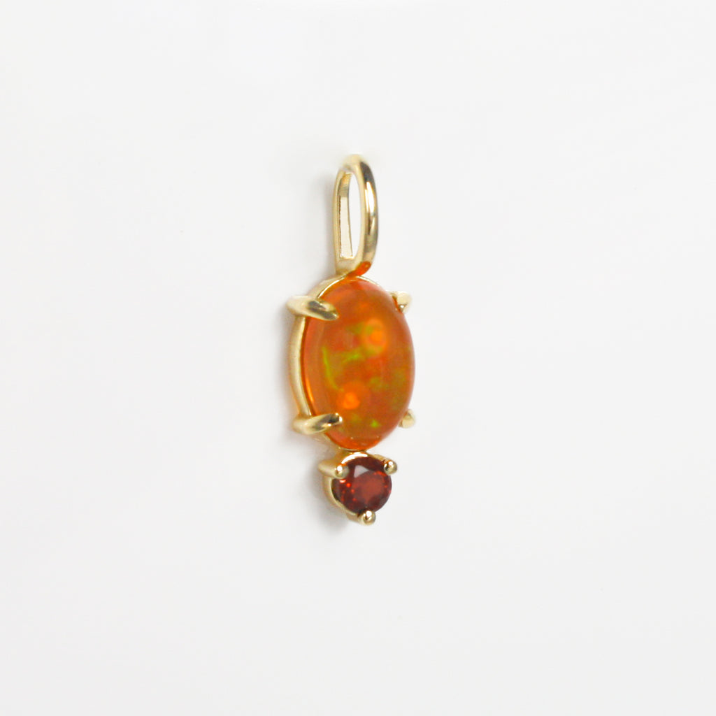 Vibrant Mexican orange crystal opal with green-red fire alongside a deep red garnet. 