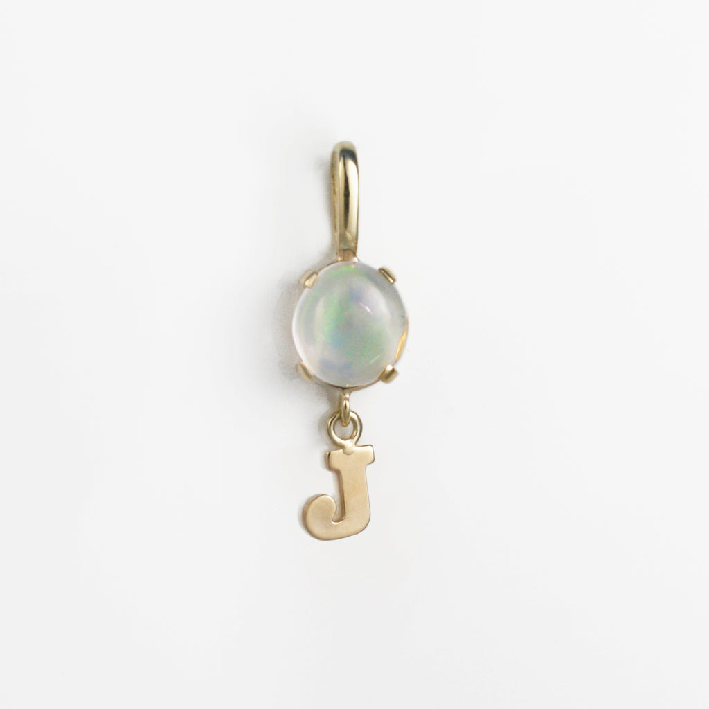 This 14k gold charm has a Mexican crystal opal attached to a dangling J initial.