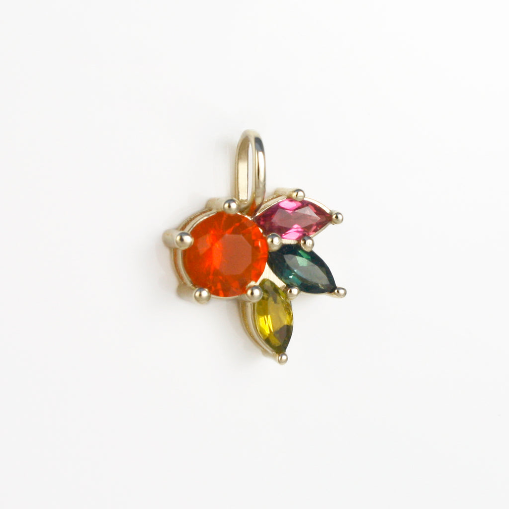 An orange-red round Mexican fire opal alongside marquise cut tourmalines in three of the most vibrant color varieties of this precious gemstone.