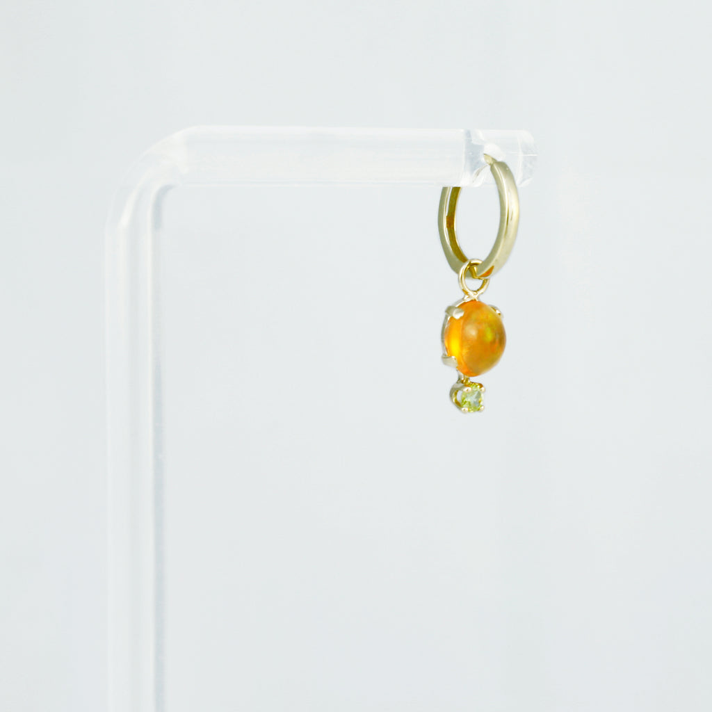 Mexican orange crystal opal set in 14k gold alongside a peridot.