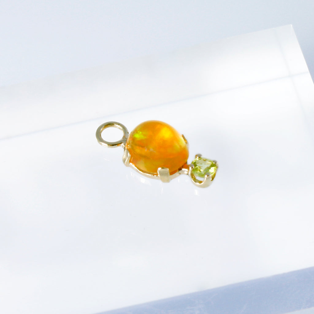 Mexican orange crystal opal set in 14k gold alongside a peridot.