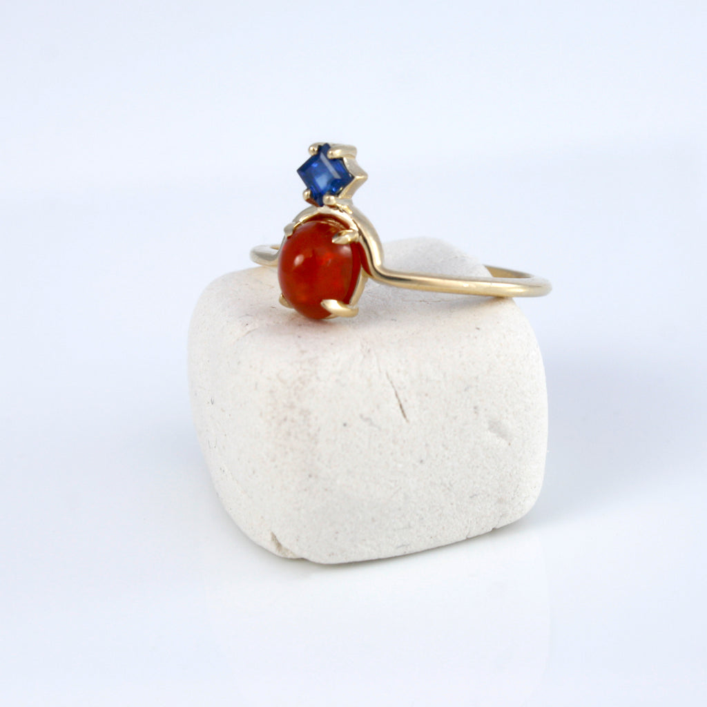 Delicate 14k gold ring featuring Mexican fire opal paired with a princess cut deep blue sapphire creating an unexpected and exciting combination. 
