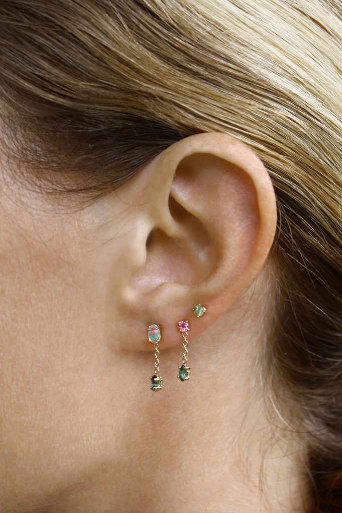 Delicate and femme earring featuring a vibrant green tourmaline anchored by a chain to a pink tourmaline. 