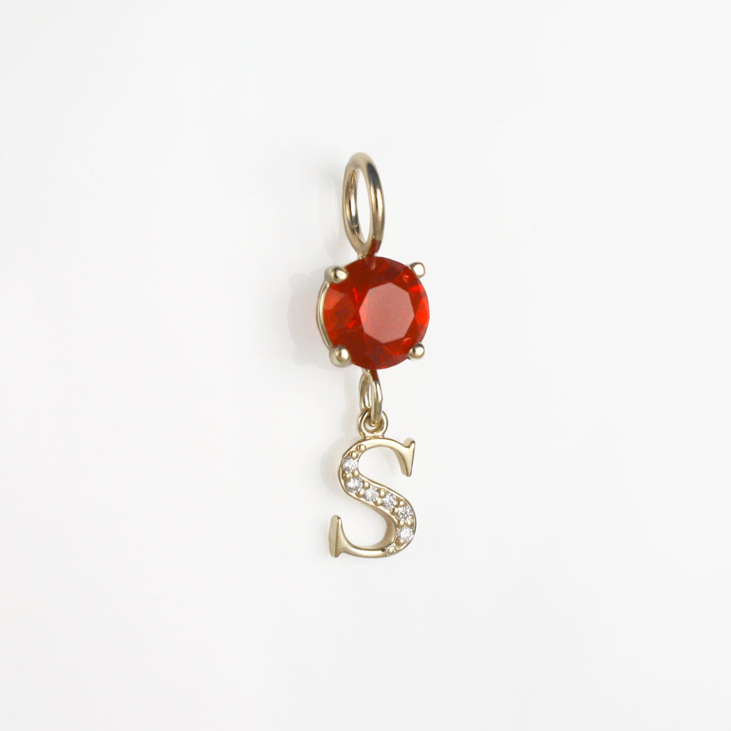 This 14k gold charm has a vibrant fire opal attached to a S initial with diamonds.