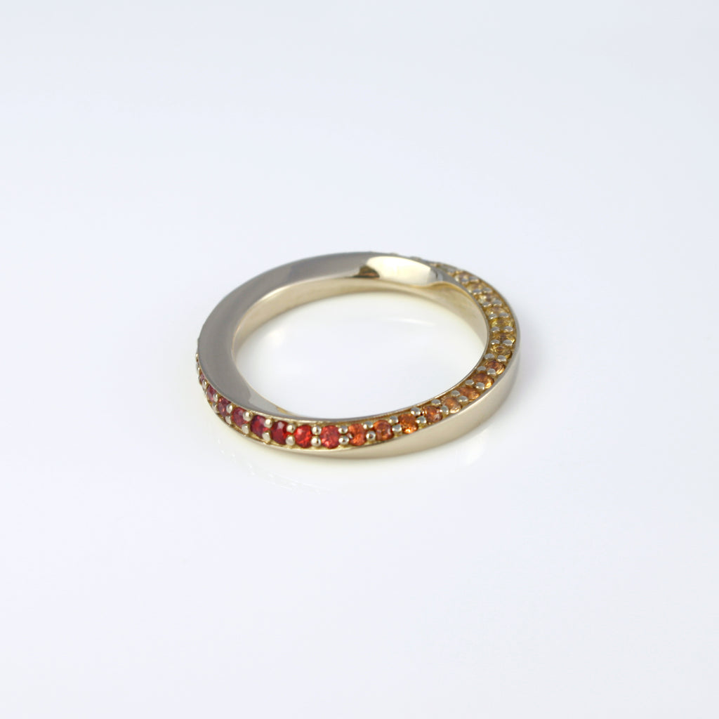 Twisted 14k gold ring sprinkled with multicolored sapphires creating the perfect rainbow gradient. A delicate and mystical piece inspired by the visible spectrum. 