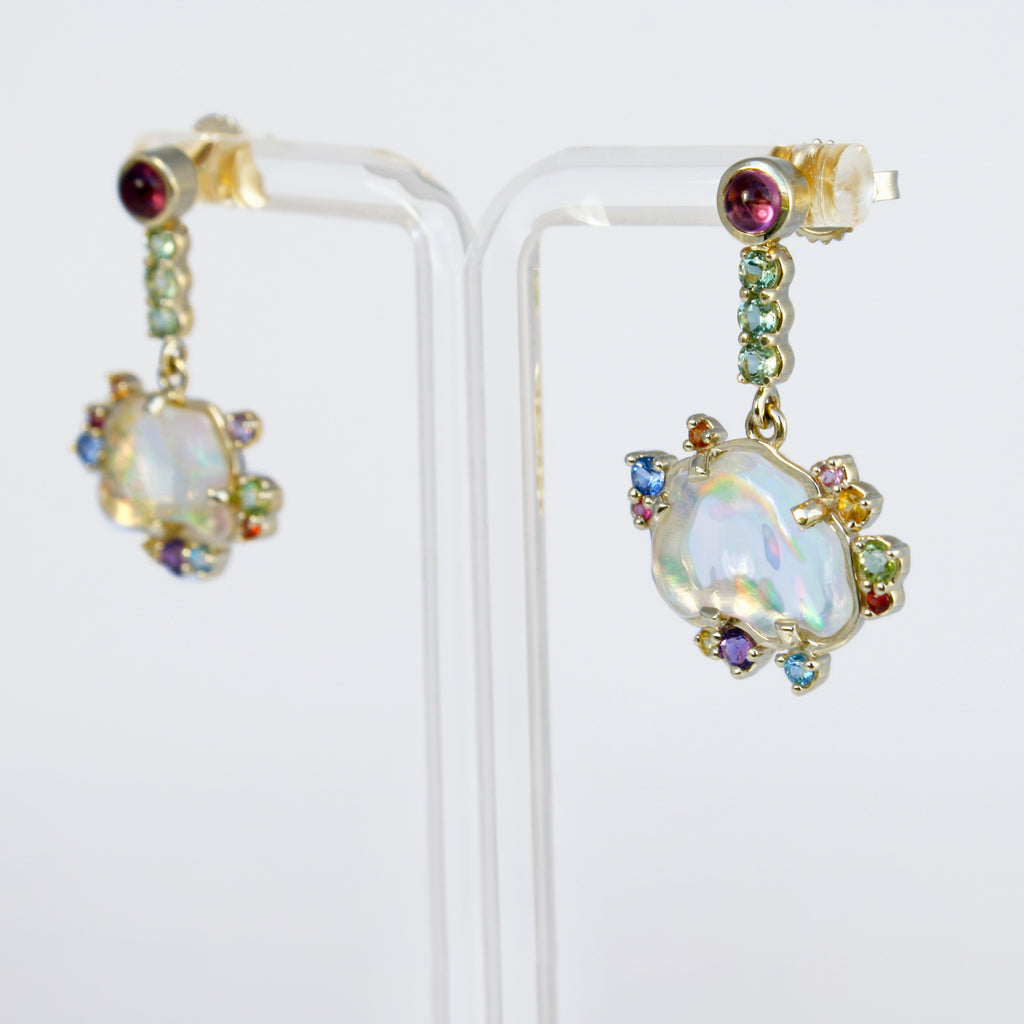 Dreamy and fascinating Mexican crystal opals with rainbow fire and flashes of color accompanied by tourmalines, sapphires, topaz, amethysts and peridots set in 14k gold.