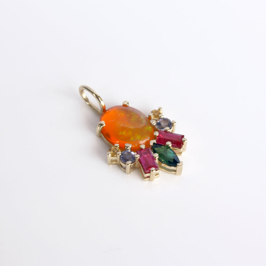 This vibrant charm features a stunning Mexican orange crystal opal beautifully contrasted by a tourmaline, rubies, iolite and citrines set in 14k gold.